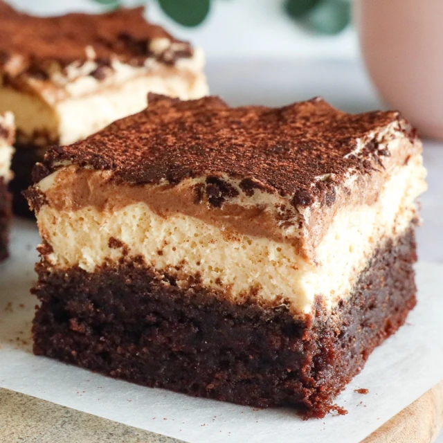 A bowl of golden Air Fryer Churro Bites coated in cinnamon sugar next to a small dish of chocolate dipping sauce.